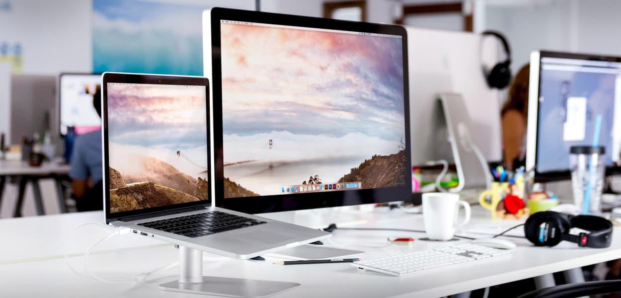 laptop and monitor on white desk